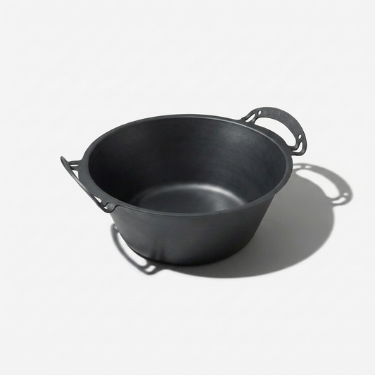 Seasoned iron pot with handles on a white background